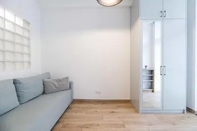 a living room with a couch and a mirror at Saguaro Deluxe Apartment Old Town Cracow in Kraków
