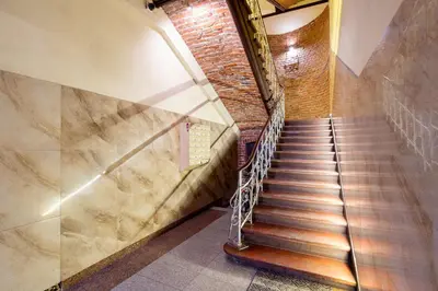 a staircase in a building with a brick wall at Miodowa Heart of Cracow Apartment by BookingHost in Kraków