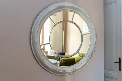 a round mirror hanging on a wall in a room at Miodowa Heart of Cracow Apartment by BookingHost in Kraków