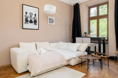 a living room with a white couch and a table at Miodowa Heart of Cracow Apartment by BookingHost in Kraków