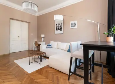 a living room with a white couch and a table at Miodowa Heart of Cracow Apartment by BookingHost in Kraków