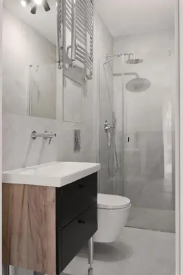 a bathroom with a sink and a shower and a toilet at Metropolis Apartments in Kraków