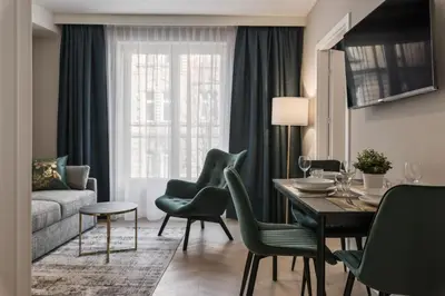 a living room with a table and chairs and a couch at Metropolis Apartments in Kraków