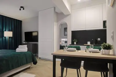 a room with a bed and a table with chairs at Metropolis Apartments in Kraków