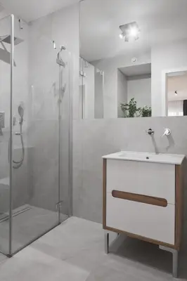 a bathroom with a sink and a shower at Metropolis Apartments in Kraków