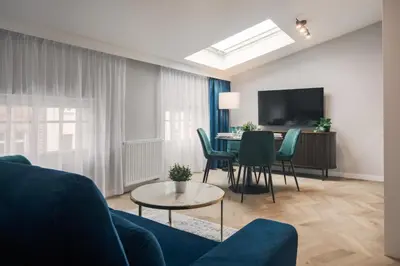 a living room with a blue couch and a table at Metropolis Apartments in Kraków