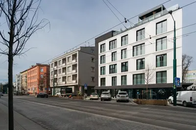 a street with cars parked in front of a building at Native Apartments Kościuszki 39I29 in Kraków