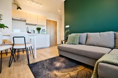 a living room with a couch and a kitchen at Green Vibe 11 Zator blisko Energylandii by Housine in Zator