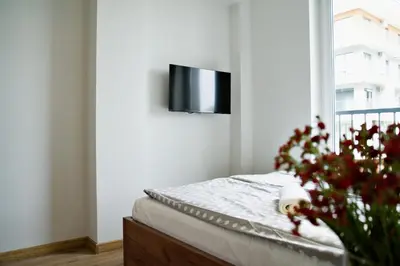 a bedroom with a bed with a tv on the wall at Apartamenty Galicja Zator by Housine in Zator