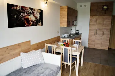 a kitchen and dining room with a table and a dining room at Apartamenty Galicja Zator by Housine in Zator
