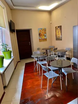 a restaurant with tables and chairs in a room at AMETYST Hostel in Kraków