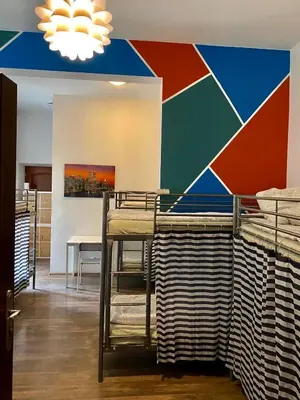 a room with two bunk beds and a colorful wall at AMETYST Hostel in Kraków