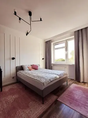 a bedroom with a bed and a window at Pod Papugami by Meadow Stay Apartments in Kraków