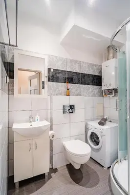 a bathroom with a toilet sink and a washing machine at Pod Papugami by Meadow Stay Apartments in Kraków