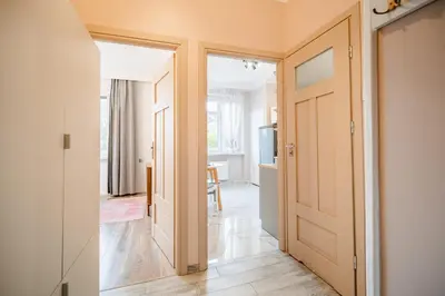 a hallway with a door leading to a living room at Pod Papugami by Meadow Stay Apartments in Kraków