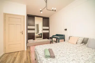 a bedroom with a bed and a desk in it at Pod Papugami by Meadow Stay Apartments in Kraków