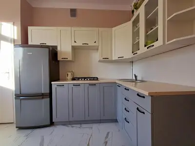 a kitchen with white cabinets and a refrigerator at Pod Papugami by Meadow Stay Apartments in Kraków