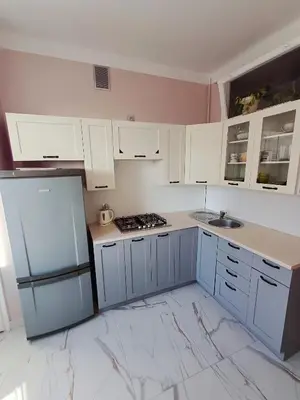 a kitchen with white cabinets and a blue refrigerator at Pod Papugami by Meadow Stay Apartments in Kraków