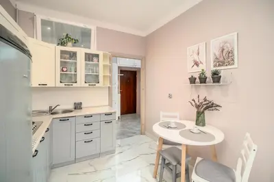 a kitchen with a table and a small table and chairs at Pod Papugami by Meadow Stay Apartments in Kraków