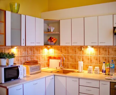 a kitchen with white cabinets and a sink and a microwave at Best location to explore Krakow Spacious 105m2 in Kraków