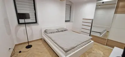a small bedroom with a bed and a mirror at Marcel Apartment in Kraków