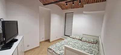 a living room with a couch and a flat screen tv at Marcel Apartment in Kraków