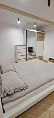 a large bed in a room with a mirror at Marcel Apartment in Kraków