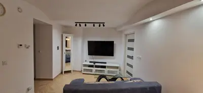 a living room with a couch and a flat screen tv at Marcel Apartment in Kraków