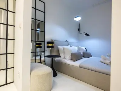 a bedroom with a bed and two windows at Grodzka by Tyzenhauz in Kraków