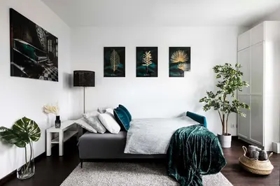 a bedroom with a bed and paintings on the wall at Cozy studio next to Cracow Vistula Boulevrads, Old Town in Kraków