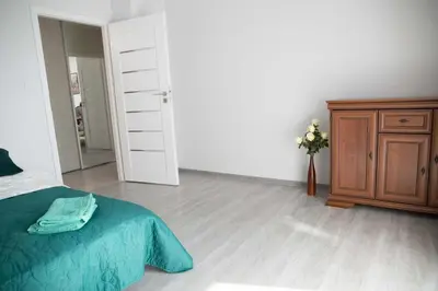 a bedroom with a bed and a wooden dresser at Pradnicka Local Apartment in Kraków