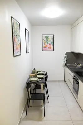 a dining room with a table and chairs in a kitchen at Pradnicka Local Apartment in Kraków