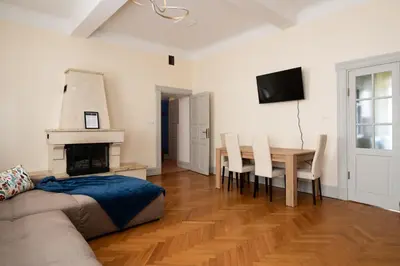 a living room with a couch and a table and a fireplace at Kings City - Central Apartment in Kraków