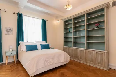 a bedroom with a bed and a large book shelf at Kings City - Central Apartment in Kraków