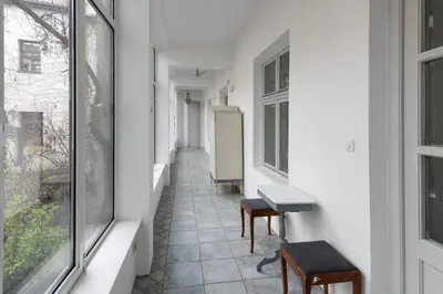 a hallway with chairs and a table and windows at Kings City - Central Apartment in Kraków