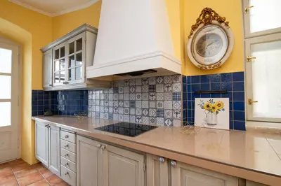 a kitchen with white cabinets and a clock on the wall at Kings City - Central Apartment in Kraków