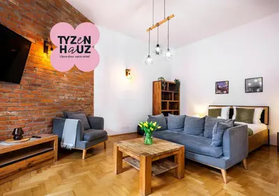 a living room with a blue couch and two chairs at Podzamcze by Tyzenhauz in Kraków