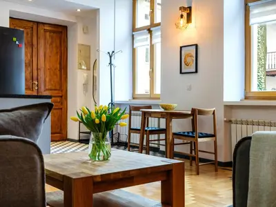 a living room with a vase of flowers on a table at Podzamcze by Tyzenhauz in Kraków