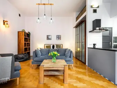 a living room with a blue couch and a table at Podzamcze by Tyzenhauz in Kraków
