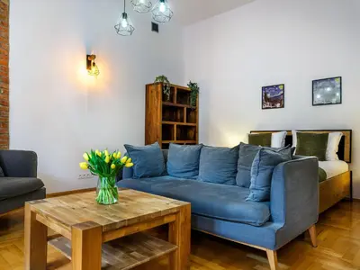 a living room with a blue couch and a table at Podzamcze by Tyzenhauz in Kraków