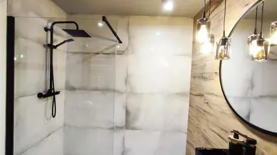 a bathroom with a shower and a mirror at Siesta Forest Apartment Relaxing Park in Kraków