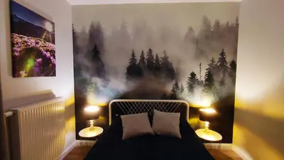 a bedroom with a bed with a painting on the wall at Siesta Forest Apartment Relaxing Park in Kraków