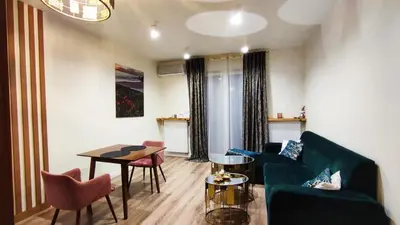 a living room with a green couch and a table at Siesta Forest Apartment Relaxing Park in Kraków