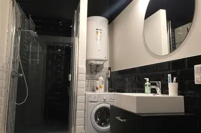 a bathroom with a sink and a washing machine at Cracow Fancy Brick #3 - Old Town in Kraków