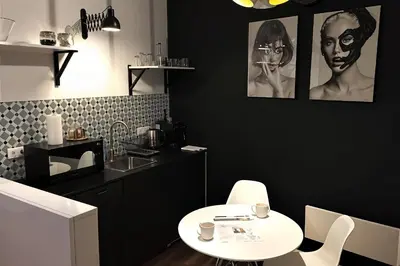 a kitchen with a white table and a black wall at Cracow Fancy Brick #3 - Old Town in Kraków