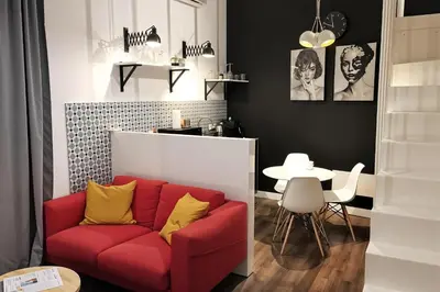 a living room with a red couch and a table at Cracow Fancy Brick #3 - Old Town in Kraków