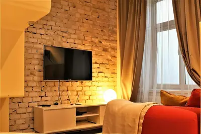 a living room with a tv on a brick wall at Cracow Fancy Brick #3 - Old Town in Kraków