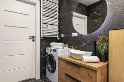 a bathroom with a washing machine and a sink at Jasny Apartament z Umeblowanym Balkonem w Krakowie Blisko Stawu by Noclegi Renters in Kraków