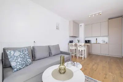 a living room with a couch and a table at Jasny Apartament z Umeblowanym Balkonem w Krakowie Blisko Stawu by Noclegi Renters in Kraków