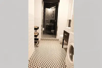 a bathroom with a black and white tiled floor at Cracow Fancy Brick #4 - Old Town in Kraków